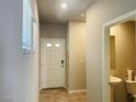 Inviting entryway features tiled floor, a powder room, and a bright white door with sidelight window at 7892 W Shelbourne Ave, Las Vegas, NV 89113