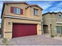 Two-story home featuring brick driveway and a two-car garage with eye-catching red door and window shutters at 7892 W Shelbourne Ave, Las Vegas, NV 89113