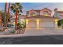 Home exterior with a two-car garage, terracotta tile roof, and mature palm trees at 8125 Sunset Cove Dr, Las Vegas, NV 89128