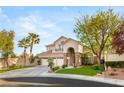 Inviting two-story home with a three-car garage, stone details, and a well-maintained lawn at 8801 Rozetta Ct, Las Vegas, NV 89134