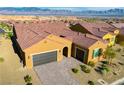 Aerial view of a home featuring a tile roof, desert landscaping, and a brick driveway at 1130 Calico Rdg, Mesquite, NV 89034