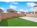 Spacious backyard features artificial grass, concrete patio and block wall for privacy at 375 Elks Peak Ave, North Las Vegas, NV 89084