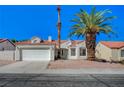 Charming single-story home with a red tile roof, a two-car garage, and desert landscaping with a large palm tree at 4010 Herblinda Ln, North Las Vegas, NV 89032