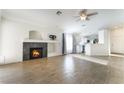 Open living room with a modern fireplace, adjacent to an all-white kitchen at 4360 Meadowlark Wing Way, North Las Vegas, NV 89084
