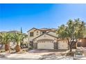 Beautiful two-story home with a three-car garage, complemented by well-manicured landscaping and mature trees at 664 Blue Crystal Creek Rd, Henderson, NV 89002