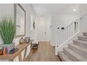 Bright foyer with wood floors, neutral walls, decorative mirror, and staircase at 2742 Zazzera Ct, Henderson, NV 89044