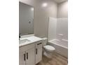 Bright bathroom featuring a shower-tub combo, wood-look floors, and a white vanity with a marble countertop at 3224 Walker River St, North Las Vegas, NV 89032