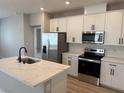 Modern kitchen featuring white cabinets, stainless steel appliances, and a center island with marble countertops at 3224 Walker River St, North Las Vegas, NV 89032