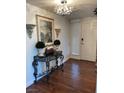 Elegant entryway with hardwood floors, decorative console table, chandelier and stylish decor at 682 Oakmont Ave # 1507, Las Vegas, NV 89109