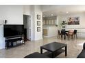 Open-concept living room with tile floors, a TV, and a view into the kitchen and dining space at 8452 Boseck Dr # 225, Las Vegas, NV 89145