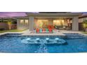 Backyard pool featuring in-pool lighting, a built-in fire pit, covered patio area, and ample seating at 103 Reflection Cove Dr, Henderson, NV 89011