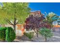 A cozy home with festive decorations sits amid well-maintained landscaping and mature trees on a sunny day at 11117 Romola St, Las Vegas, NV 89141