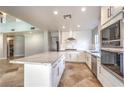 Modern kitchen featuring white cabinetry, stainless steel appliances, a large center island with countertop, and a stylish tile floor at 1112 Caraway Ln, Las Vegas, NV 89144
