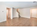 Bright and airy living room with neutral walls, tile flooring, and staircase at 137 Desert Pond Ave, Henderson, NV 89002