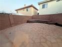 Spacious backyard with a patio area, block wall fencing, and a tiered planting bed at 141 Gryffin Ave, Las Vegas, NV 89123