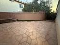 Backyard featuring a large flagstone area, green space, and secure block wall fencing for privacy at 141 Gryffin Ave, Las Vegas, NV 89123