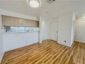 View of living area with wood floors, white walls, access to kitchen, and a glimpse of the front entry at 2044 Mesquite Ln # 202, Laughlin, NV 89029