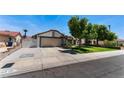 Home exterior featuring mature trees and long driveway leading to the two car garage at 2803 Marathon Dr, Henderson, NV 89074