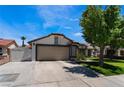 Home exterior featuring mature trees and long driveway leading to the two car garage at 2803 Marathon Dr, Henderson, NV 89074