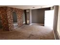 A spacious living room with a unique brick accent wall and neutral carpeting at 3717 Casey Dr, Las Vegas, NV 89120