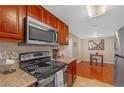 Updated kitchen with stainless steel microwave, range and wooden cabinets and a view to the dining area at 4390 Sandy River Dr # 1, Las Vegas, NV 89103