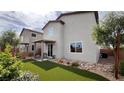 Private backyard with a covered patio, synthetic grass, and low maintenance desert landscaping at 5151 Capucina St # Lot 1, Las Vegas, NV 89122