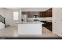 Modern kitchen features a large island, stainless steel appliances, and dark wood cabinetry for culinary enthusiasts at 5169 Capucina St # Lot 4, Las Vegas, NV 89122