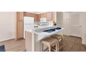 Kitchen with a breakfast bar, white appliances, and hardwood floors at 5235 Caspian Springs St # 101, Las Vegas, NV 89120