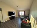 Comfortable living room with a large TV, stylish laminate flooring, and a window at 5320 Portavilla Ct # 203, Las Vegas, NV 89122