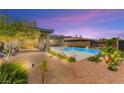 Spacious backyard showcasing the pool, lush landscaping, and serene outdoor living space at 59 Reflection Bay Dr, Henderson, NV 89011