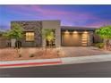 Contemporary home featuring stone accents, a modern garage door, and desert-friendly landscaping at 59 Reflection Bay Dr, Henderson, NV 89011
