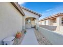 Inviting entryway with an arched doorway and desert landscaping with mature cacti at 6064 Isola Peak Ave, Las Vegas, NV 89122