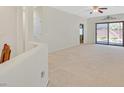 Spacious living room with neutral carpeting, sliding glass doors and access to other rooms at 6064 Isola Peak Ave, Las Vegas, NV 89122