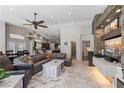 Spacious living room featuring a stone fireplace, tile floors, and an open floor plan to the kitchen and dining area at 7401 Bridlehorne Ave, Las Vegas, NV 89131