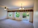 Open living room featuring neutral carpeting, a ceiling fan, and natural light at 7668 Broadwing Dr, North Las Vegas, NV 89084