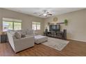 Bright living room with comfortable seating, large windows, and an entertainment center at 776 Flowing Meadow Dr, Henderson, NV 89014