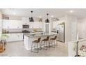 The kitchen showcases white cabinets, granite counters, pendant lighting, stainless steel appliances, and a large island with stools at 8316 Gold River Ct, Las Vegas, NV 89113