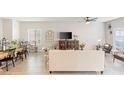 Open-concept living room with modern decor, comfortable seating, neutral colors, and view to dining area and backyard at 8316 Gold River Ct, Las Vegas, NV 89113