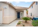 Close-up of the front door with a tiled roof overhang, neat landscaping, and charming exterior details at 8564 Lost Gold Ave, Las Vegas, NV 89129