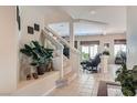 Inviting entryway featuring a staircase with white railing, neutral walls, and stylish decor at 890 Socorro Song Ln, Henderson, NV 89052