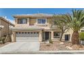 Two-story home with tan stucco, two car garage, rock landscaping and mature palm tree at 890 Socorro Song Ln, Henderson, NV 89052
