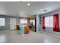 Bright open-concept living area featuring tile flooring, kitchen island, and ample natural light at 9476 Milkweed Canyon Ave, Las Vegas, NV 89166