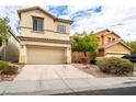 Attractive two-story home with a two-car garage, desert landscaping, and a neutral-colored exterior at 9750 Maple Sugar Leaf Pl, Las Vegas, NV 89148