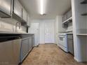 Galley kitchen with gray cabinets, white appliances, quartz countertops, tile floors, and recessed lighting at 9975 Peace Way # 1140, Las Vegas, NV 89147