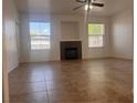 A spacious living room with a fireplace, neutral walls, tile floor, and bright light from two windows at 9975 Peace Way # 1140, Las Vegas, NV 89147