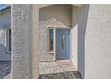 Covered entry featuring a light blue front door, textured stucco walls, and brick paving at 10654 Robin Hill Ave, Las Vegas, NV 89129