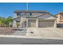 Home exterior featuring a two-car garage, walkway, and neutral stucco finish, under a clear blue sky at 10654 Robin Hill Ave, Las Vegas, NV 89129