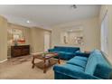 Cozy living room with blue sofas, neutral walls, and natural light creates an inviting atmosphere at 10858 Morning Frost St, Las Vegas, NV 89179