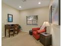 Cozy office space with a desk, comfortable armchair, and natural light from the window at 10858 Morning Frost St, Las Vegas, NV 89179