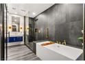 Sleek bathroom with a soaking tub, a glass-enclosed shower, and modern fixtures in contrasting styles at 2407 Ridgeline Wash St, Las Vegas, NV 89138
